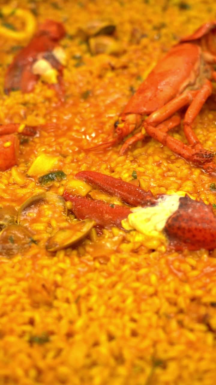A plate of food with a yellow sauce and a lot of red shrimp