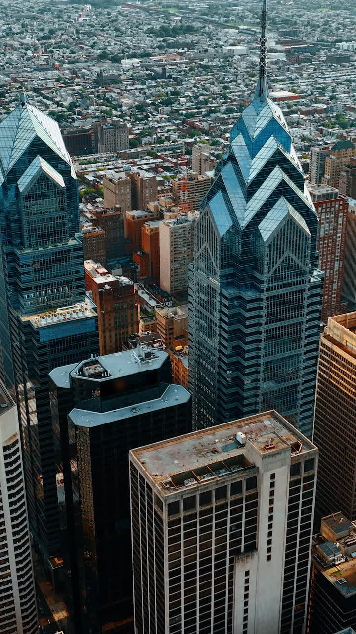 Approaching marvelous skyscraper complex of beautiful Philadelphia. Plain cityscape and river at backdrop. Top view. Vertical video