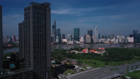 Aerial-Vietnam,-Ho-Chi-Minh-City-iconic-buildings-of-Skyline-on-sunny-clear-day-featuring-architecture,-and-Saigon-River