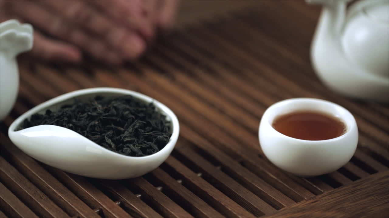 ceremonia tradicional del té chino. primer plano de una taza de té china de mano femenina