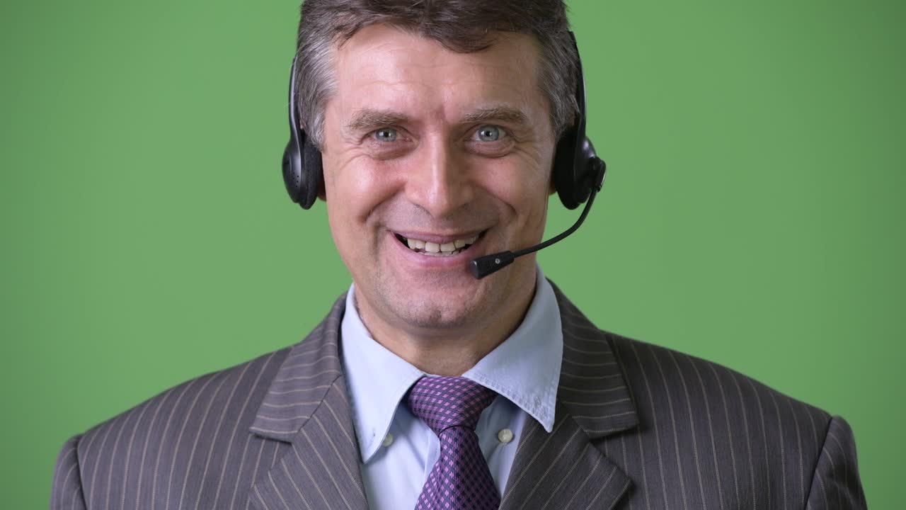 hombre de negocios maduro y guapo contra un fondo verde