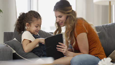 una niña y su madre usando un digital