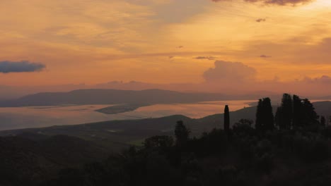 Imágenes-Aéreas-De-La-Icónica-Laguna-De-La-Bahía-De-Monte-Argentario,-Frente-Al-Antiguo-Casco-Antiguo-De-Orbetello,-Cerca-Del-Parque-Natural-Maremma-En-Toscana,-Italia-Con-Nubes-Dramáticas-Que-Cubren-El-Cielo-Al-Amanecer