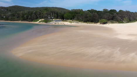 Rotierende-Drohnenaufnahme-Des-Korogoro-Creek-Mit-Wind,-Der-Sand-über-Eine-Sandbank-Am-Hutkopf-Von-New-South-Wales,-Australien,-Bläst