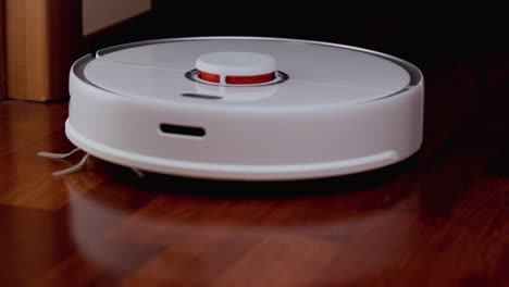 smart robot vacuum cleaner with lidar on wood floor. robot vacuum cleaner performs automatic cleaning of the apartment. 4k slow motion 100 fps, prores 422, 10 bit