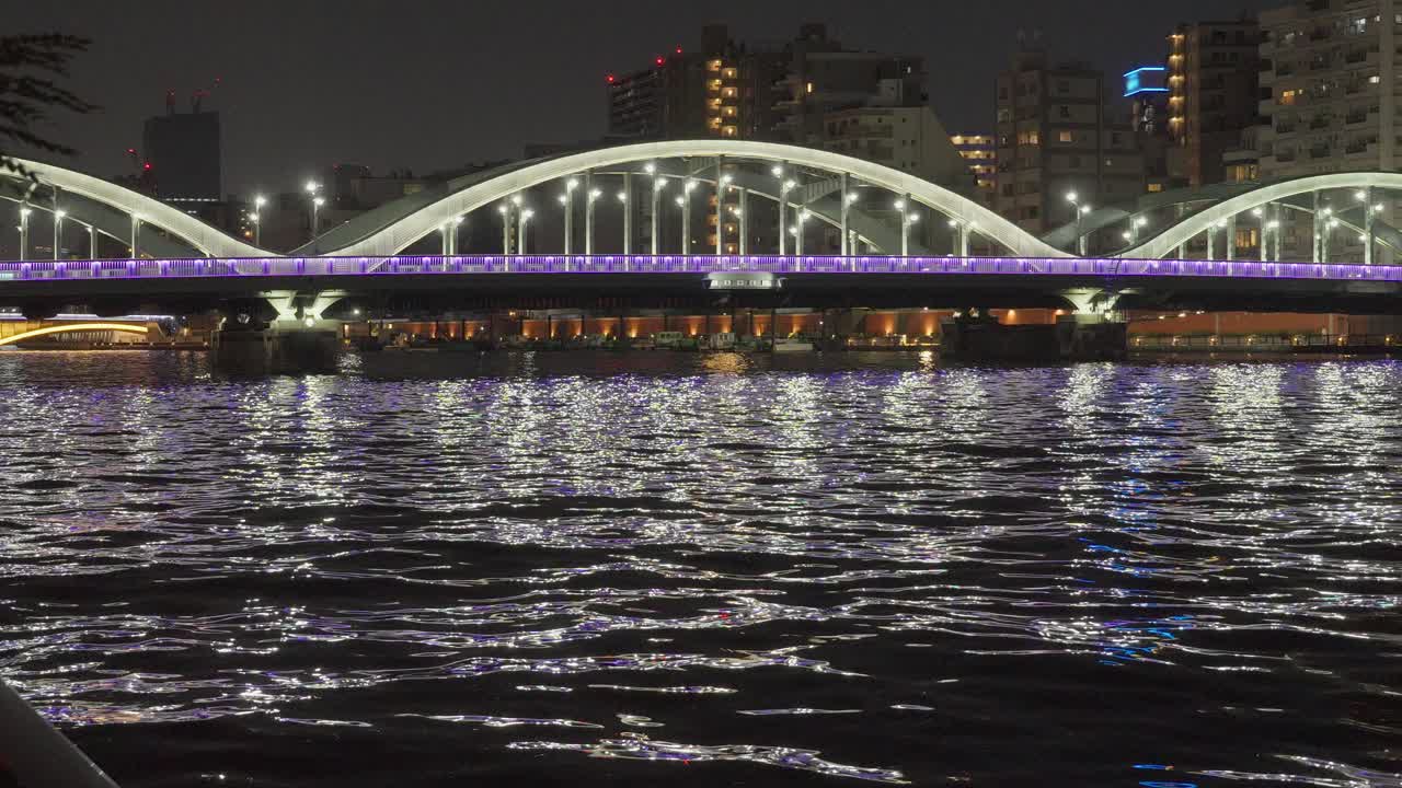 Night view of a bridge over water with city lights