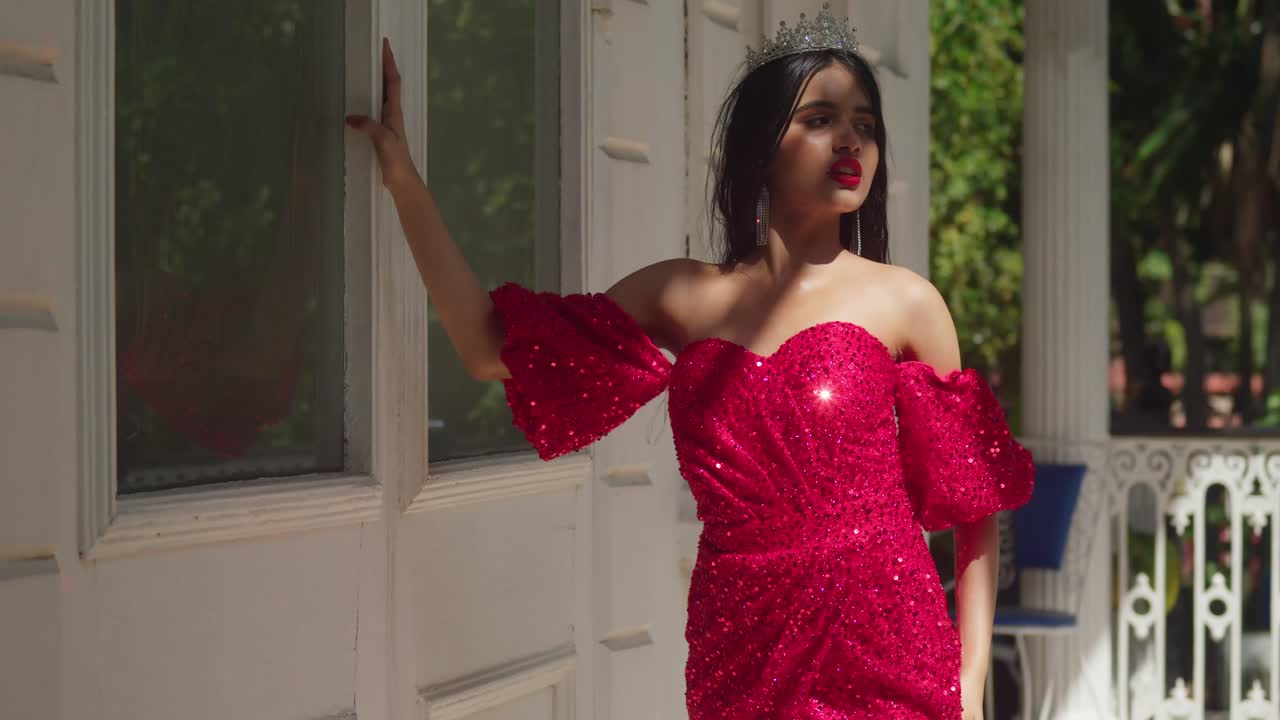 카리브해 성의 석벽 안에서 젊은 여자의 은 드레스가 고대 방을 가로질러 우아하게 흐른다.