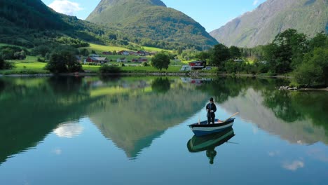 Una-Mujer-En-El-Barco-Pesca-Un-Pez-Girando-En-Noruega.