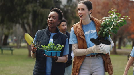 a diverse group of volunteers plant trees in a park