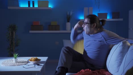 the man watching the game at night is happy when he wins.