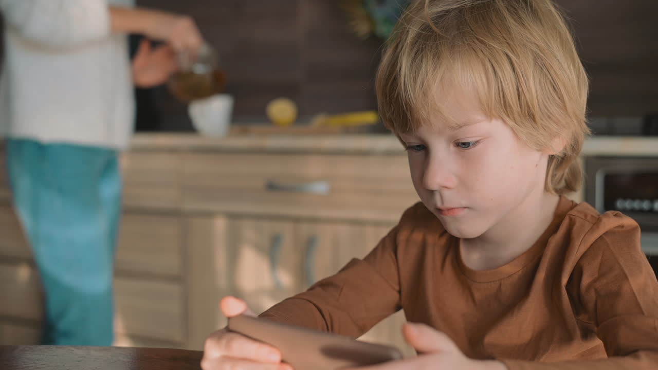 Bambino e madre che guardano lo smartphone a casa