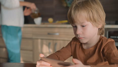 Niño-Y-Madre-Viendo-El-Teléfono-Inteligente-En-Casa