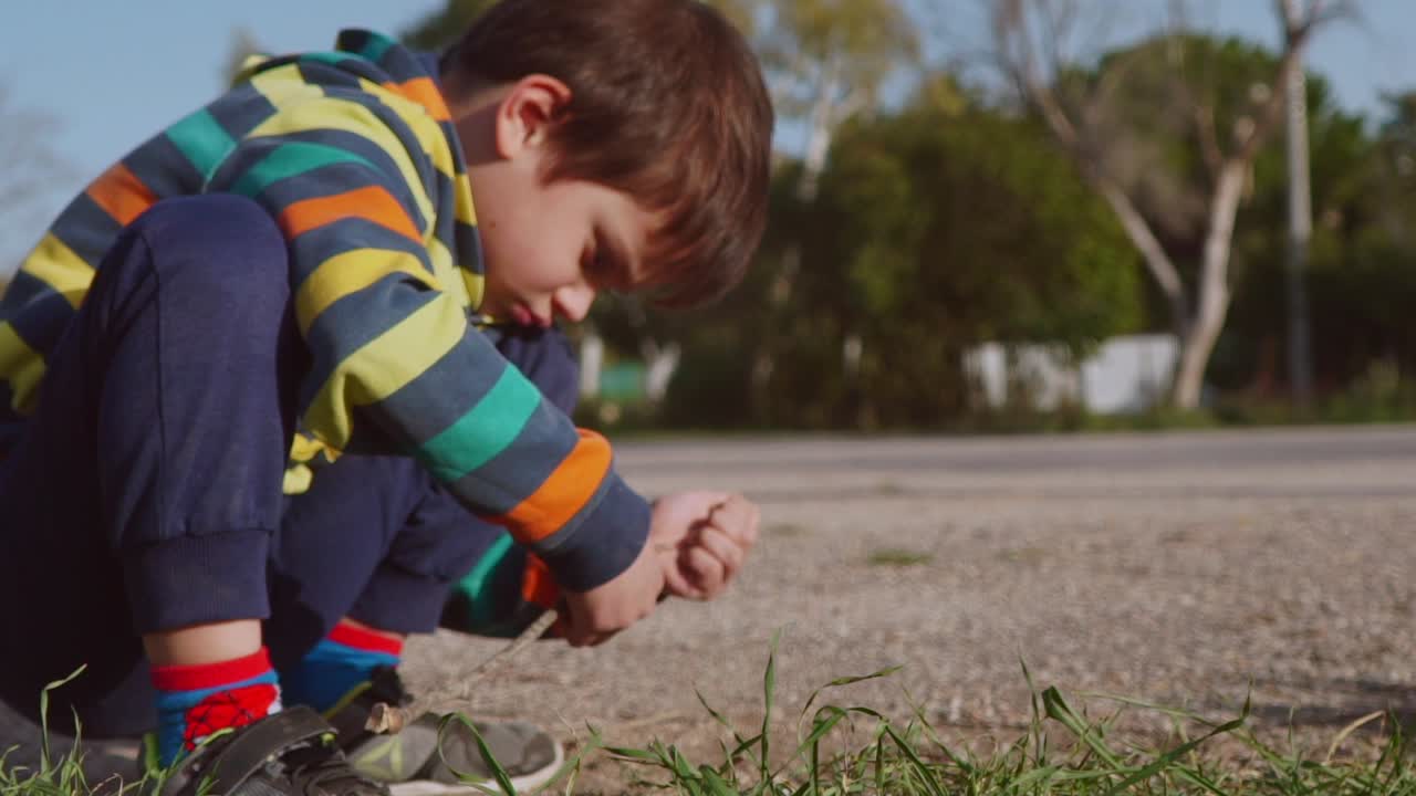 primer plano, vista lateral de un niño caucásico jugando con tierra en los campos