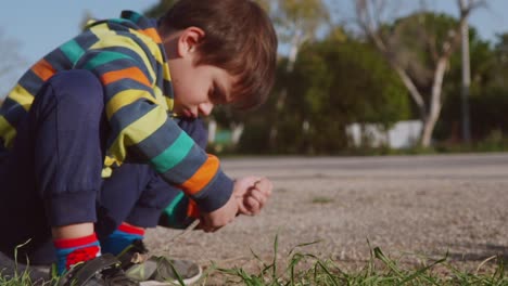 Tight-close-up-,-side-view-of-caucasian-boy-playing-with-soil-in-the-fields