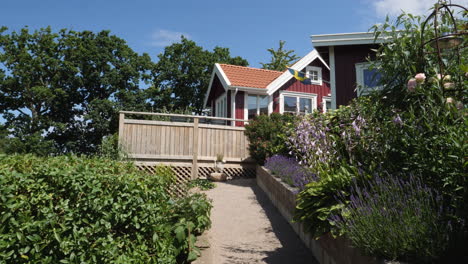 Rote-Sommerhäuser-Mit-Balkon-Und-Schwedischer-Flagge-Im-Sommer