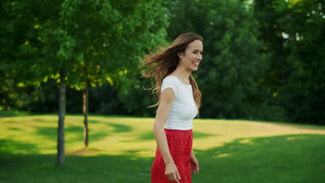 woman throwing frisbee disc in park. boy and girl taking frisbee disk outdoors