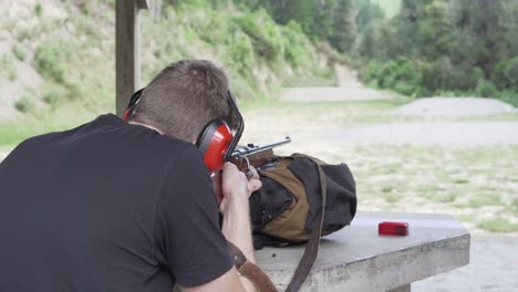 firearms range with a man aiming at target in nature landscape