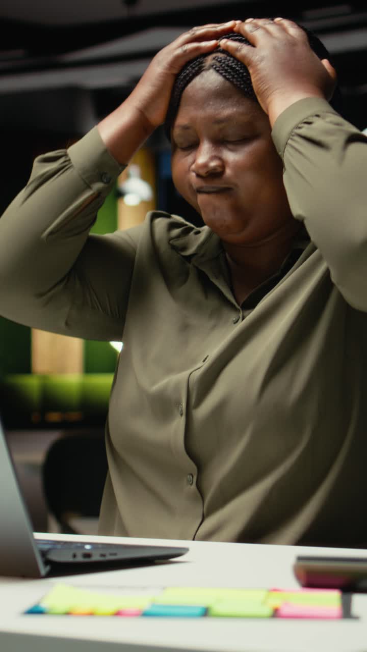 Vertical Video Black female assistant tensed and burdened in dark office after hours