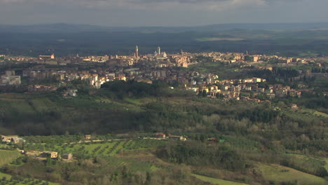 Aerial-revealing-shot-of-the-churches-and-residential-area-in-Sienna,-italy