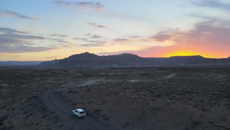 Drone-Vuela-Sobre-Un-Automóvil-Que-Conduce-A-Través-De-Una-Montaña-Humeante-Hacia-El-Punto-Alstrom,-Lago-Powell