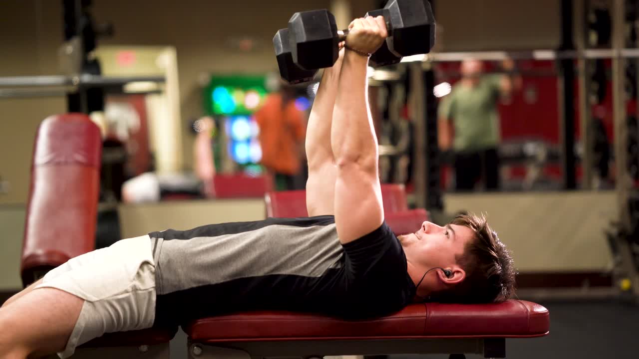 거짓말 삼두근 풀오버 또는 프레스를하고있는 십대 보디 빌더의 근접 촬영 측면 샷