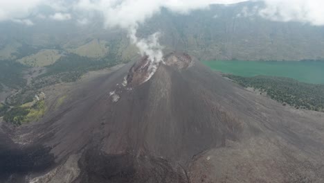 Close-tilting-shot-of-active-volcano-with-fumes,-Rinjani-on-Lombok-in-Indonesia