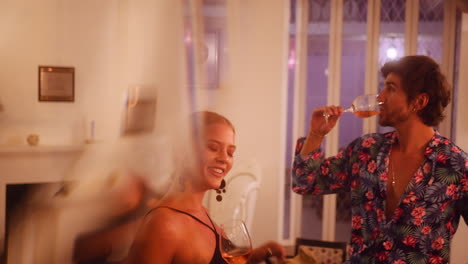 woman dancing in black dress having wine with friends while enjoying a luxury resort holiday getaway. evening drinks and fun dating concept.