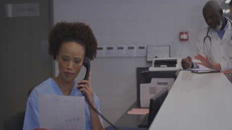nurse receptionist answering telephone reading document at hospital desk, with floating data charts