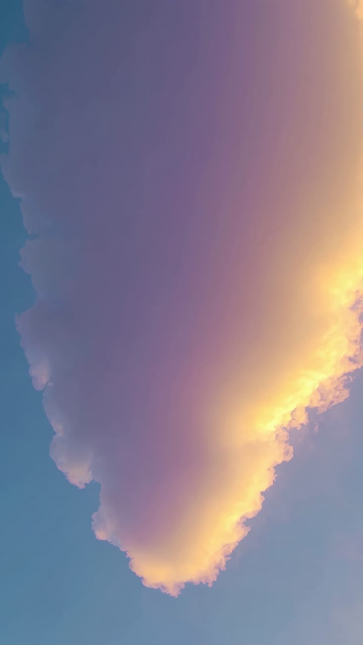 A dreamy, pastel-hued sky with soft clouds, captured from a low angle