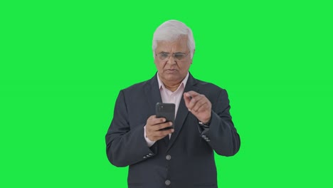 Indian-senior-manager-using-mobile-phone-Green-screen