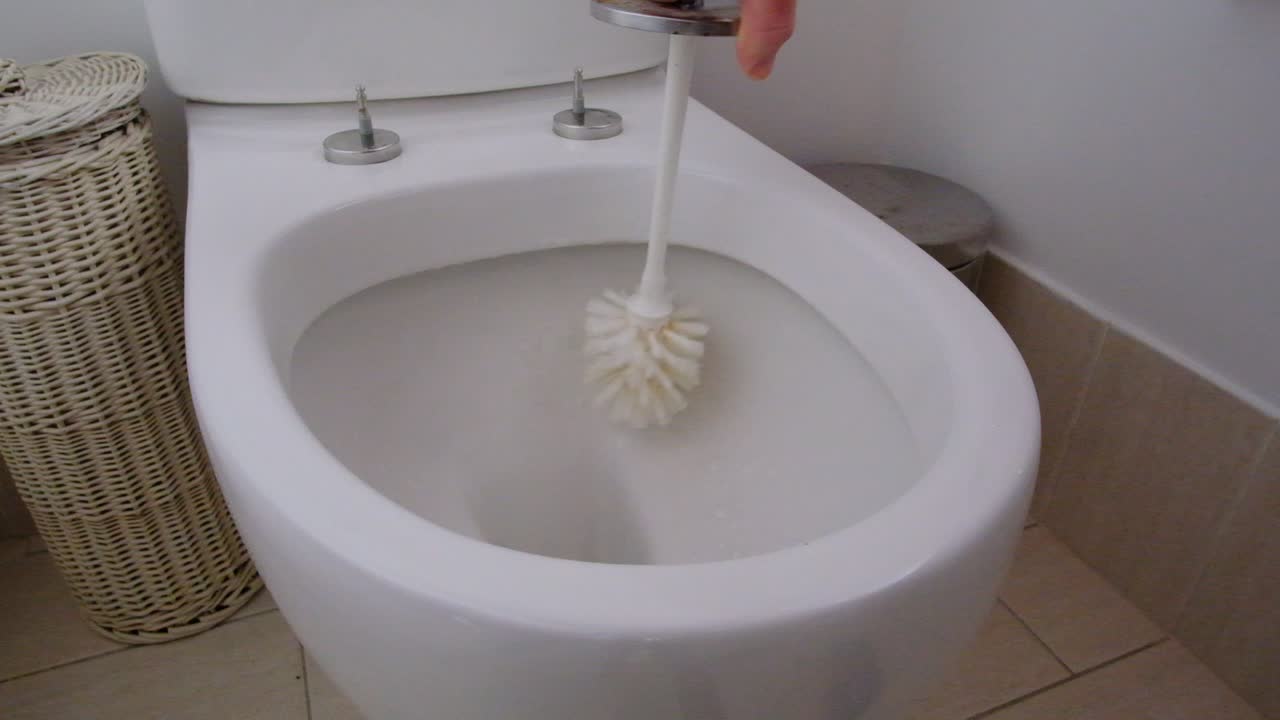 Cleaning toilet bowl with toilet brush