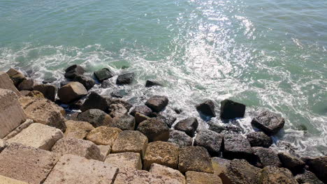 Una-Vista-De-La-Costa-Rocosa-Con-Agua-Brillante-Bajo-La-Luz-Del-Sol,-Que-Retrata-La-Belleza-Natural-Costera-De-Cádiz