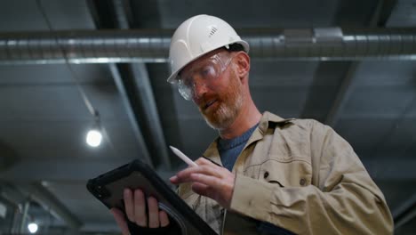 worker inspecting equipment with tablet