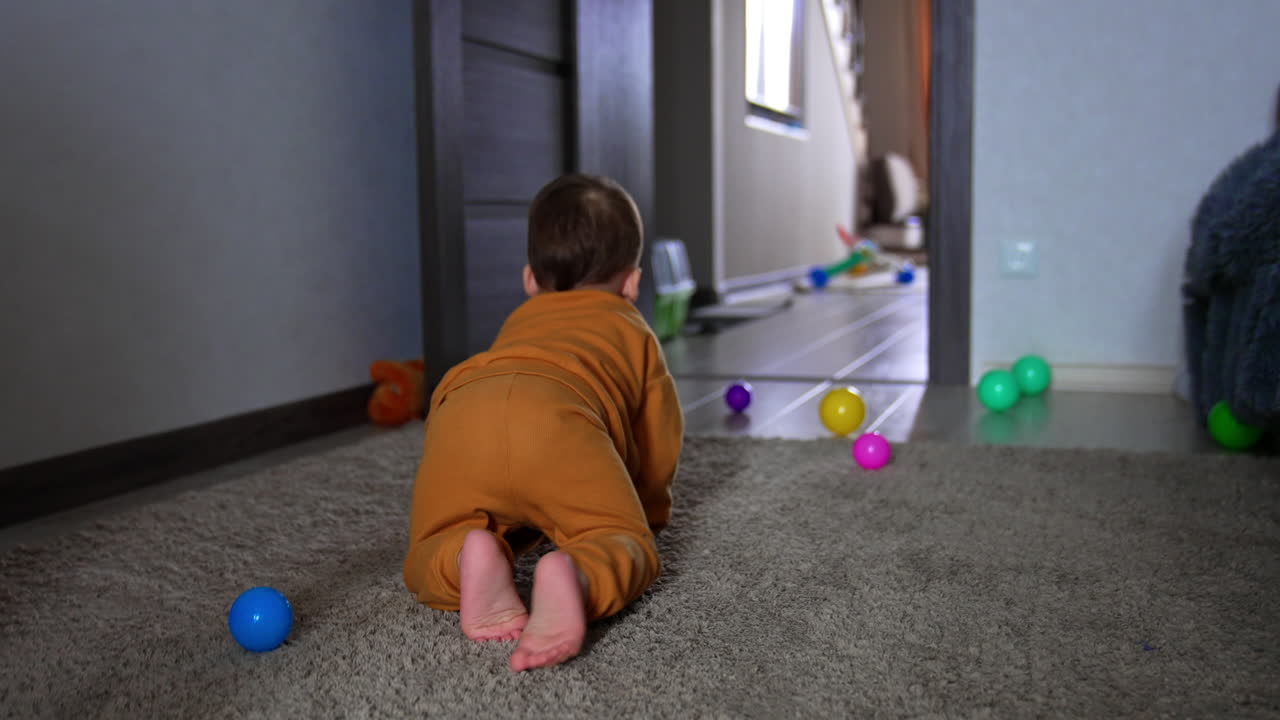 Baby Crawling in a Playroom with Colorful Balls