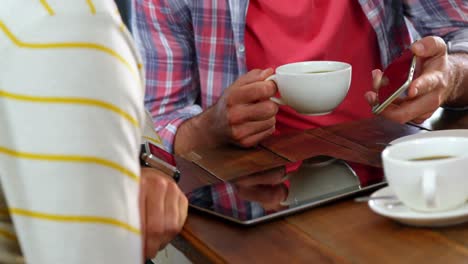 Freunde-Interagieren-über-Mobiltelefon,-Während-Sie-Kaffee-Trinken