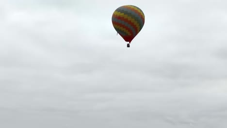 colorful hot air balloon parachute flying under cloudy sky, aerial view