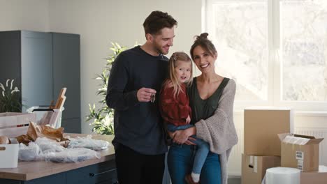 retrato de una feliz familia caucásica con una hija en un nuevo apartamento.