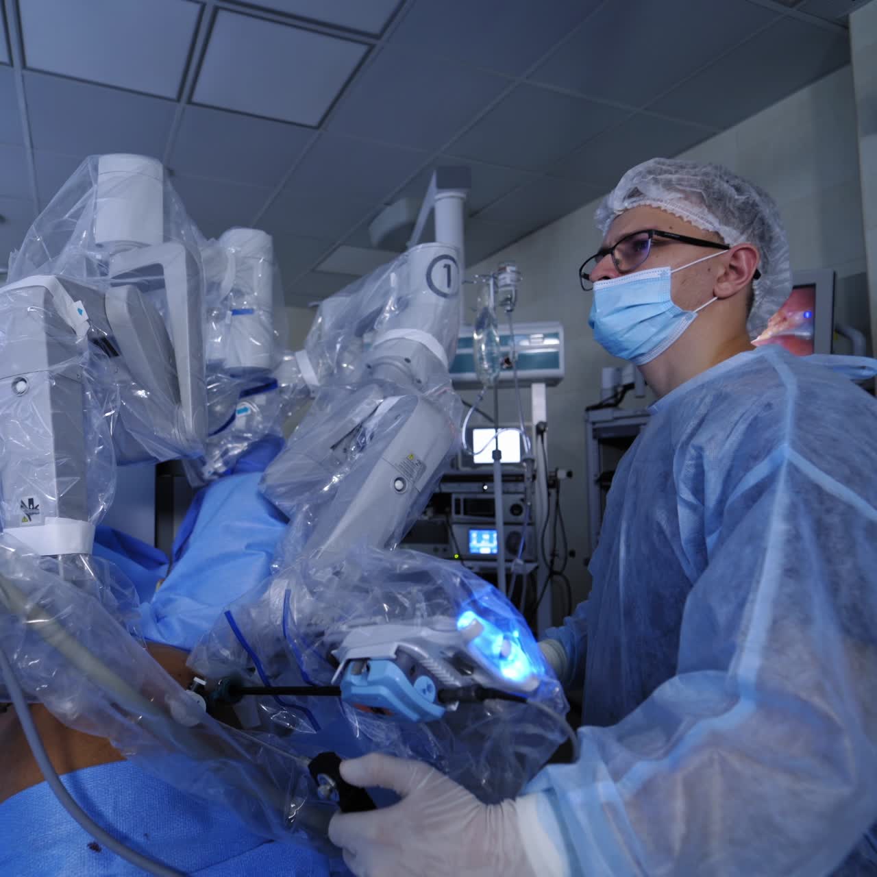 Da vinci surgical system. Doctor near the futuristic robotic equipment. Minimally invasive surgery. Robotic arms doing a microsurgery on patient.