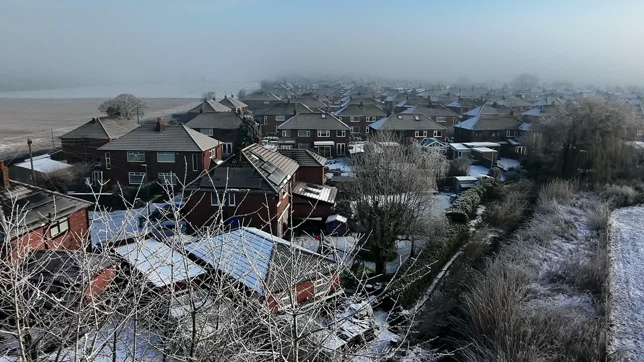 Frosty morning mist covering British small town neighbourhood houses on the horizon aerial view