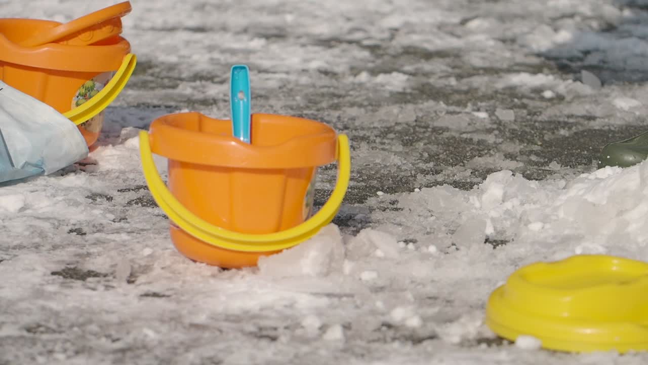 Children's plastic buckets and toys on ice