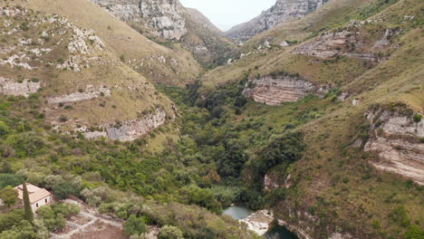 cavagrande del cassibile canyon nature reserve with stream and lush vegetation in avola, syracuse, italy