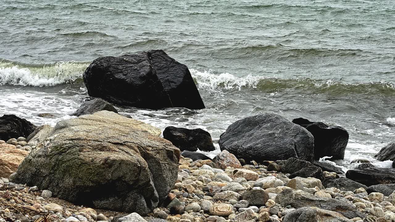 Experience the mesmerizing sight of ocean waves crashing against a rocky shore.