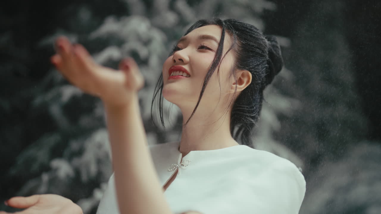 Woman in a white dress playing with snow