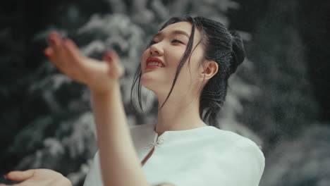 woman in a white dress playing with snow