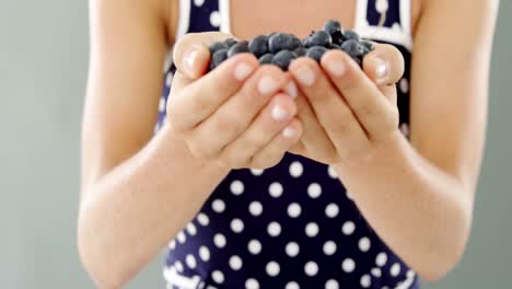 close-up of woman holding blueberry