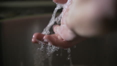 prevention coronavirus close up of man washing hands under running water in sink