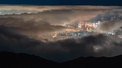 night time lapse zoom over tai mo shan, hong kong with clouds moving. beautiful night city lights of tai mo shan ,cityscapes at mountain in hong kong. time lapse clouds on the top of mountain