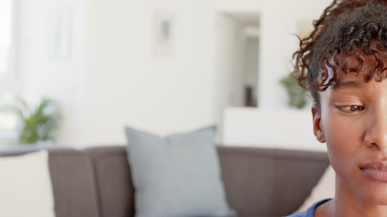 La telecamera riprende, una donna afroamericana parla sul divano di casa, sbatte le palpebre e sposta lo sguardo, con spazio per il testo.