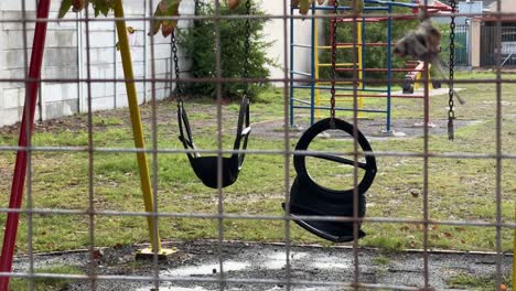 a broken swing in a kids play park in cape town, south africa.
