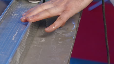 person using a tile cutter